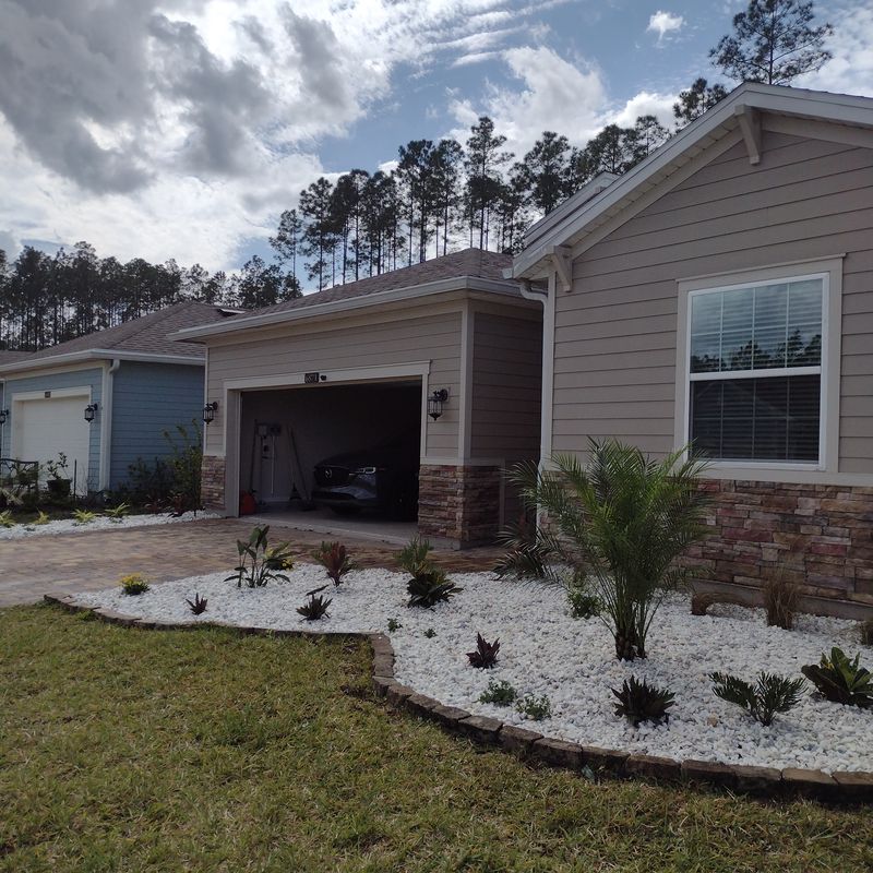 Front-yard landscape design with fresh beds, rock, and sod